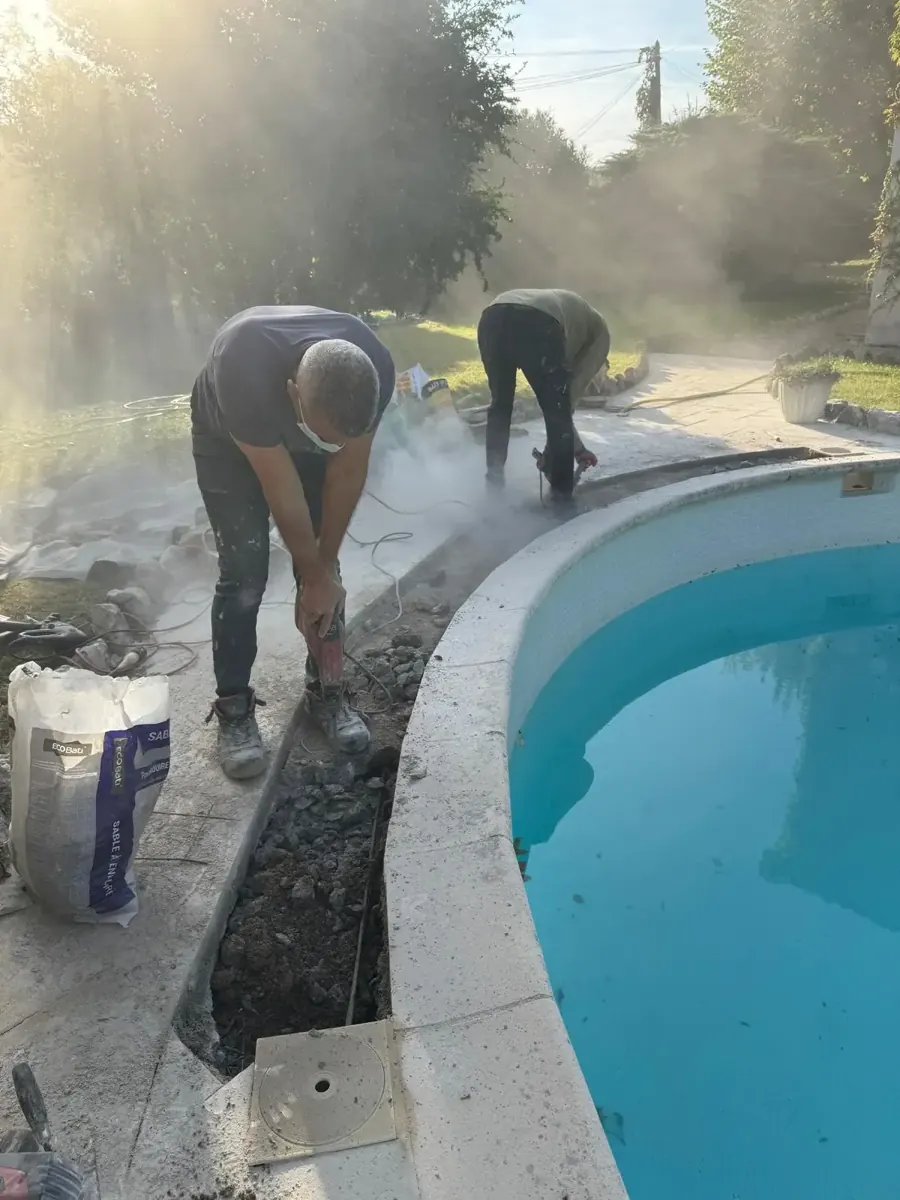 Découpe de la dalle béton le long de la margelle pour accéder au tuyau de skimmer